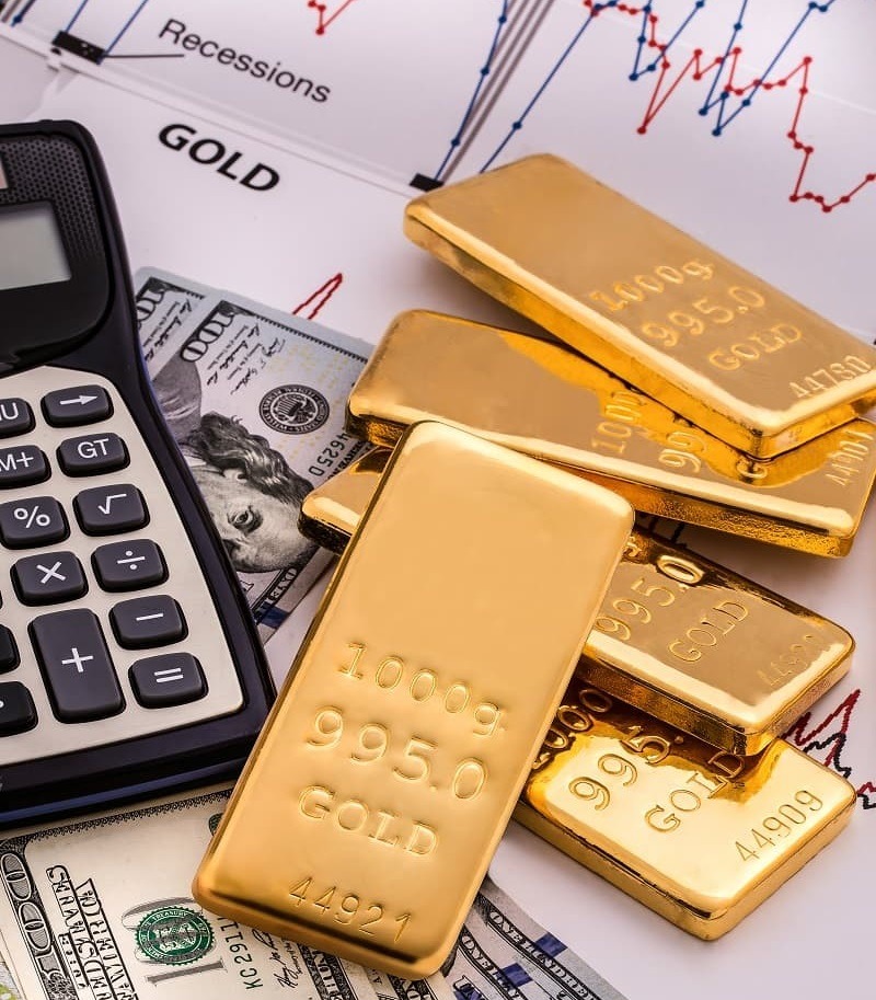 pile de lingots d'or avec une calculatrice à coté