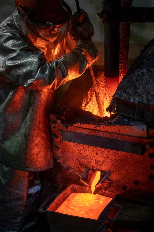 image d'un fondeur en train de fondre l'or dans un moule
