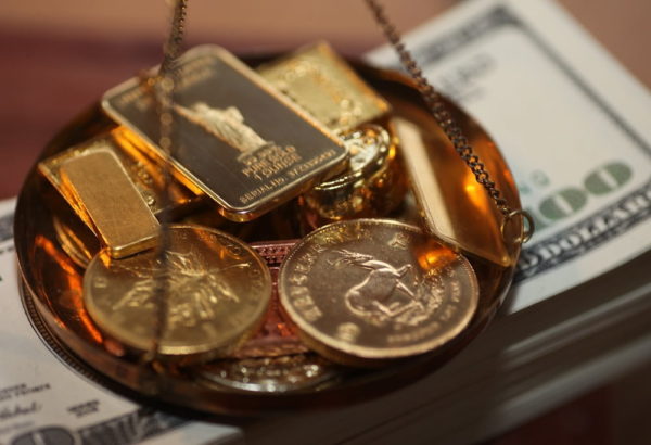 image de lingots d'or dans une balance qui tombe sur des dollars